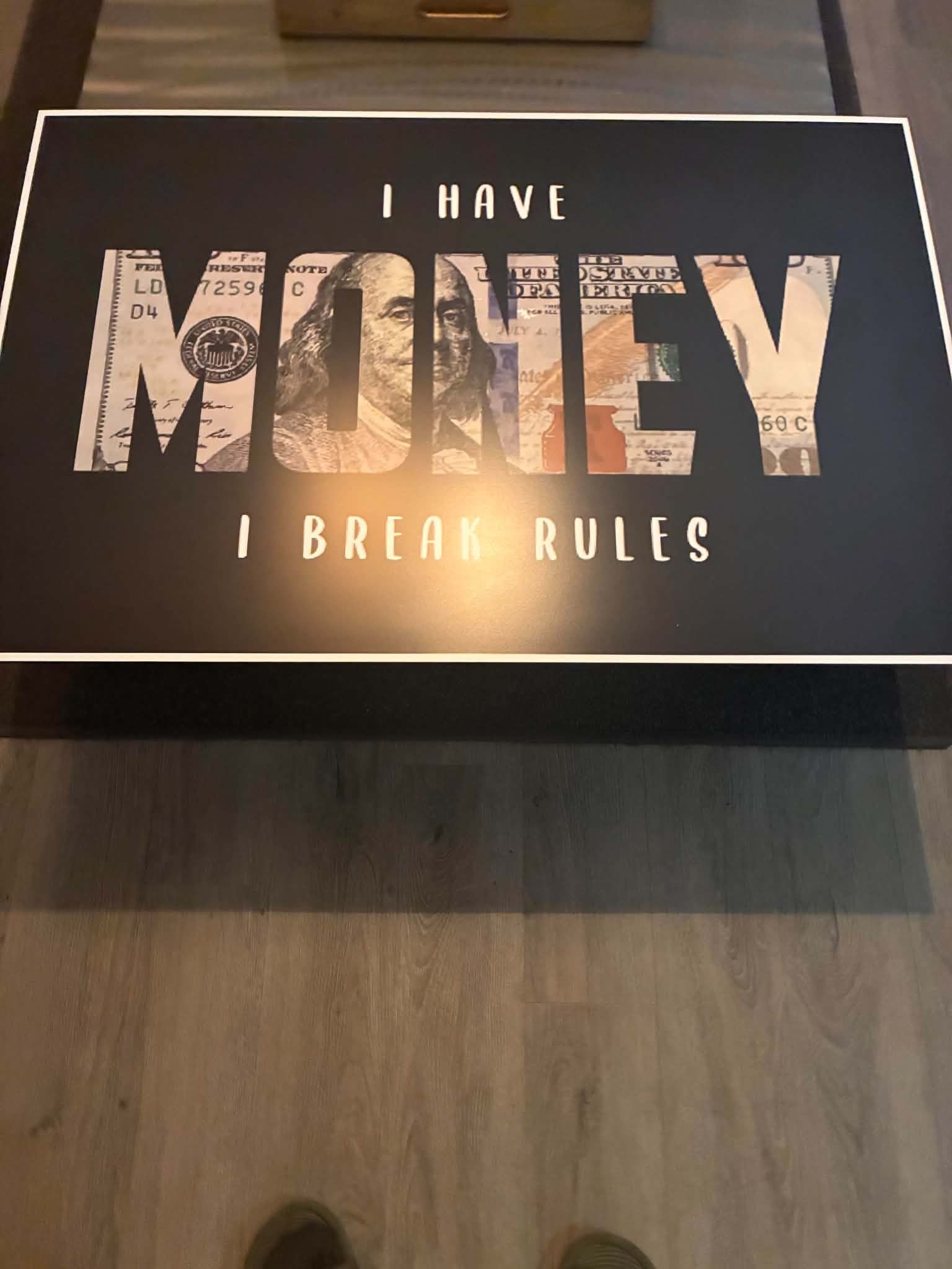 Photo of a motivational money art print where the giant word MONEY is filled in with a hundred-dollar bill pattern